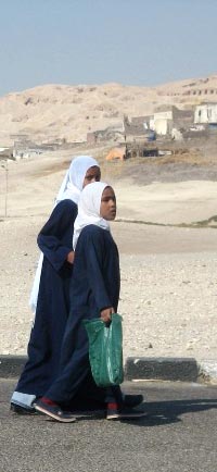 Young girls walking in a village in Upper Egypt. The Temple of Hatsheput can be seen in the background, 2007
